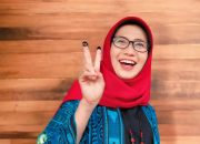 Tampak Anggun, Cabup Bunda Indah Gunakan Hak Pilih Datang Ke TPS Dengan Ciri Khas Kerudung Merahnya