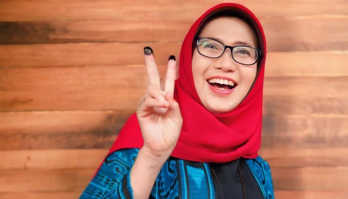 Tampak Anggun, Cabup Bunda Indah Gunakan Hak Pilih Datang Ke TPS Dengan Ciri Khas Kerudung Merahnya