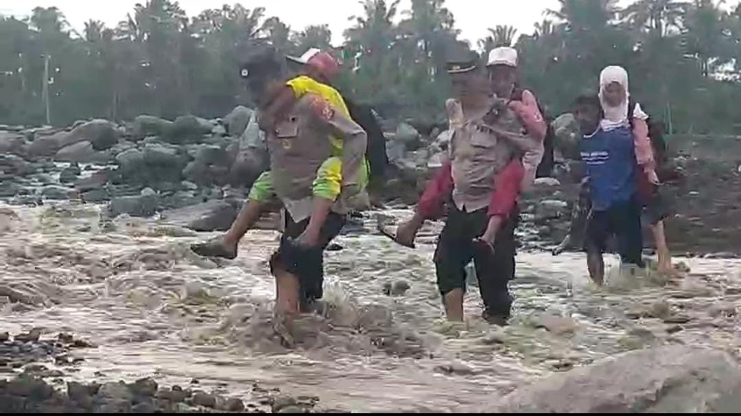 FOTO: Aksi kemanusiaan jajaran Polsek Candipuro, Kabupaten Lumajang, saat membantu gendong anak-anak sekolah menyeberangi derasnya aliran Sungai Regoyo