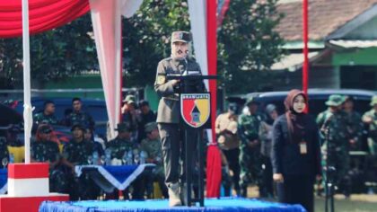 FOTO : Bupati Lumajang berdiri di Podium sebagai Inspektur Upacara saat Peresmian Buka TMMD ke-129 TA 2026