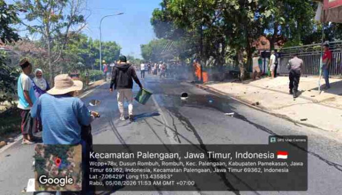 FOTO : Warga setempat dan beberapa anggota kepolisian yang berada di area sekitar berusaha memadamkan api yang dipicu oleh laka-lantas