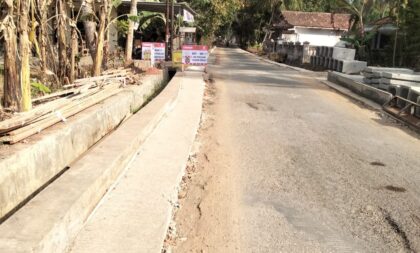 FOTO: Lokasi proyek rekonstruksi jalan Ellak Daya – Mandala tampak bahan material U-Dith untuk saluran irigasi