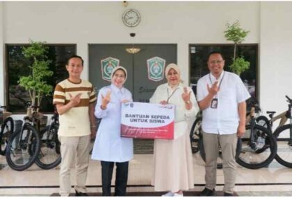 FOTO : Bupati Lumajang saat menyerahkan bantuan enam unit sepeda untuk anak yatim di sekolah MI Hasyim Asy’ari Yosowilangun Kidul melalui dukungan Bank Jatim.